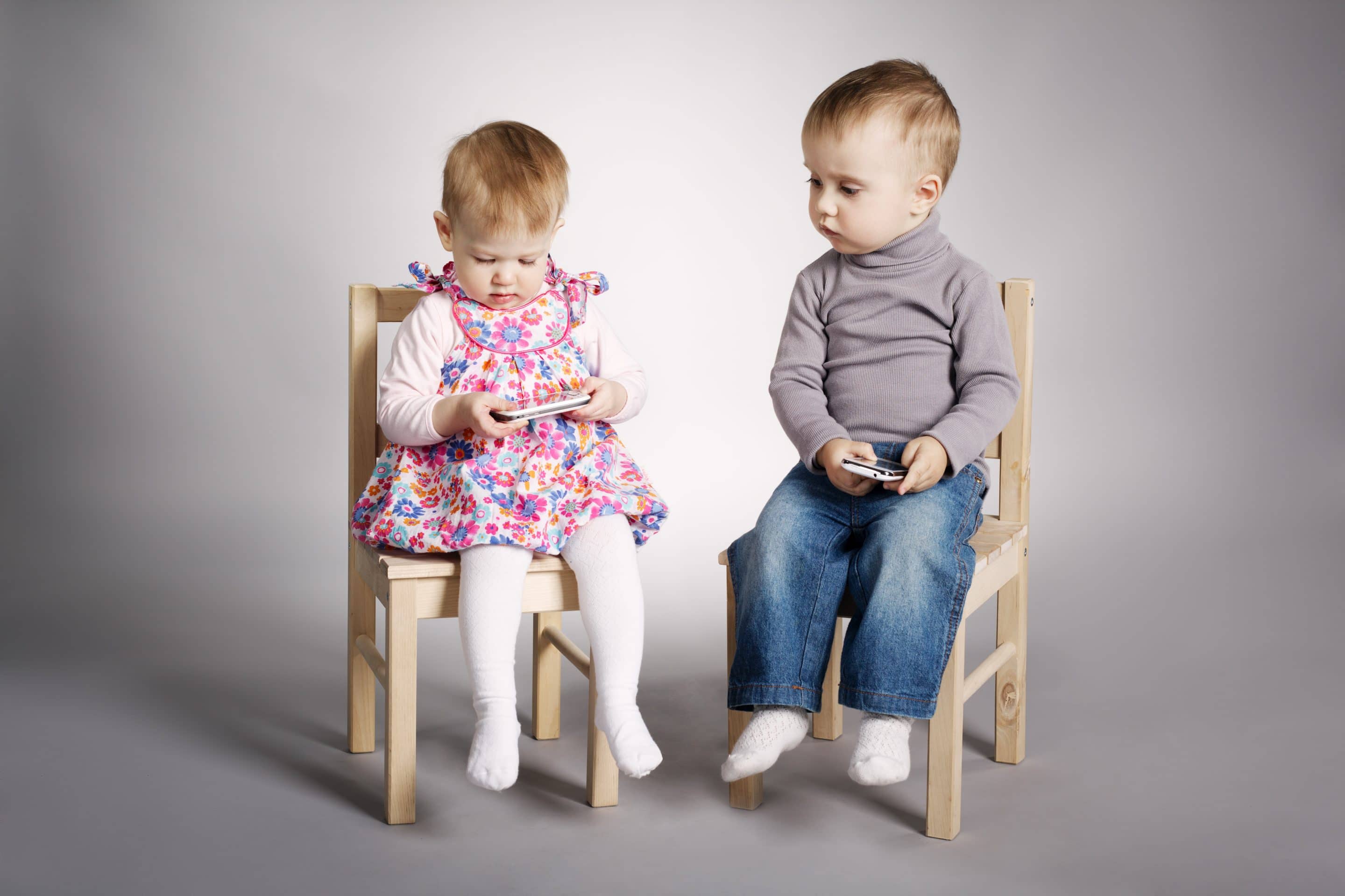boy and girl playing with mobile phones